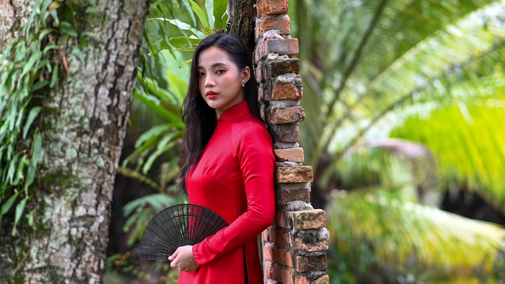 a woman in a red dress holding a black umbrella