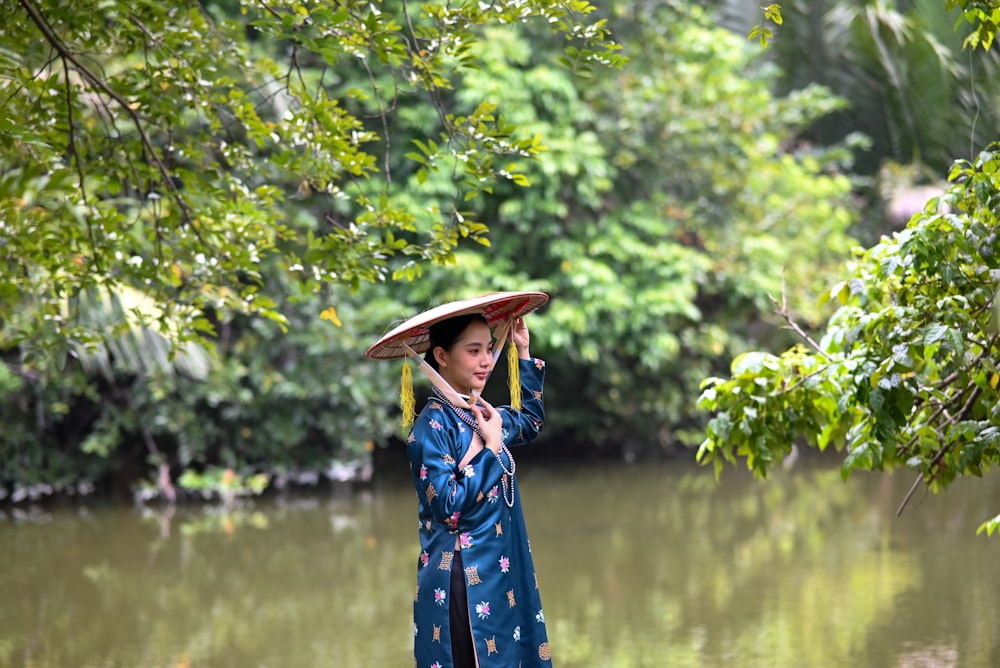 Una mujer con un kimono azul sostiene un paraguas sobre su cabeza