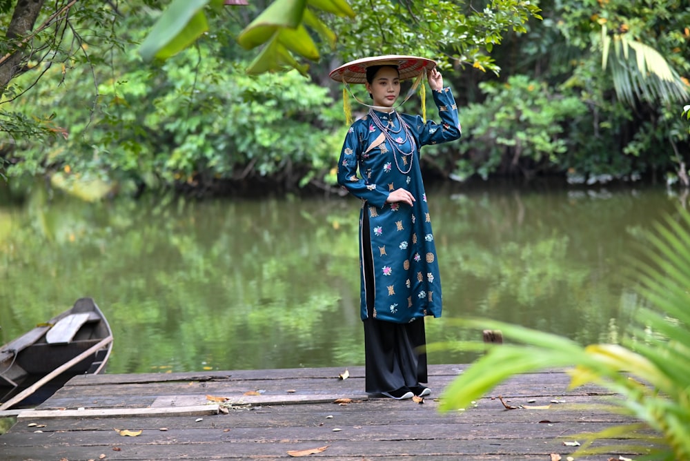 a woman standing on a dock holding an umbrella over her head