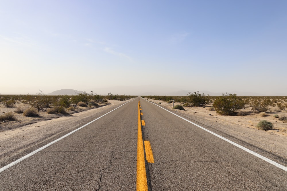 an empty road in the middle of the desert