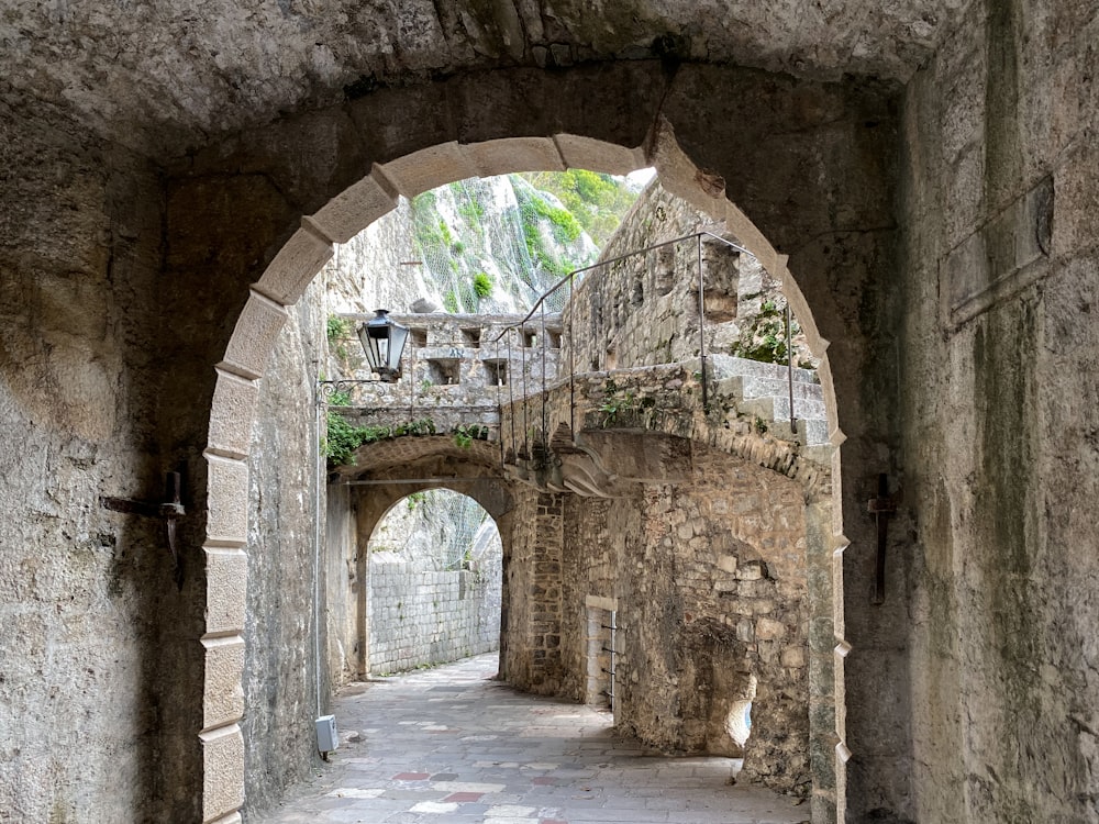 a narrow alley with a stone bridge in the middle