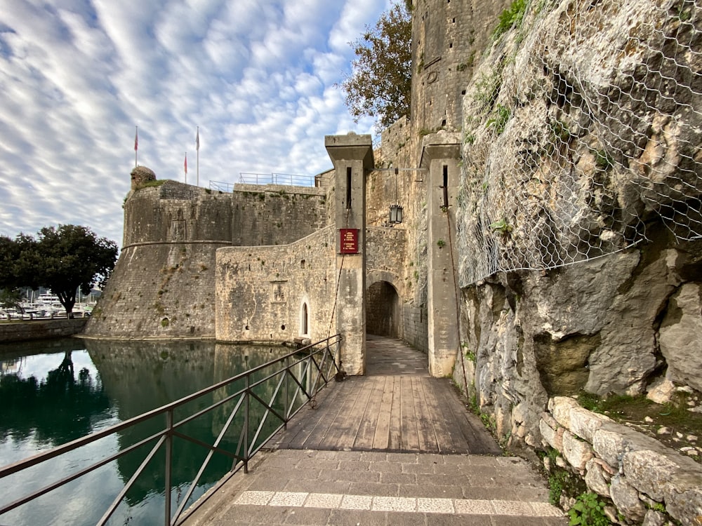 uma passarela que leva a um castelo ao lado de um corpo de água