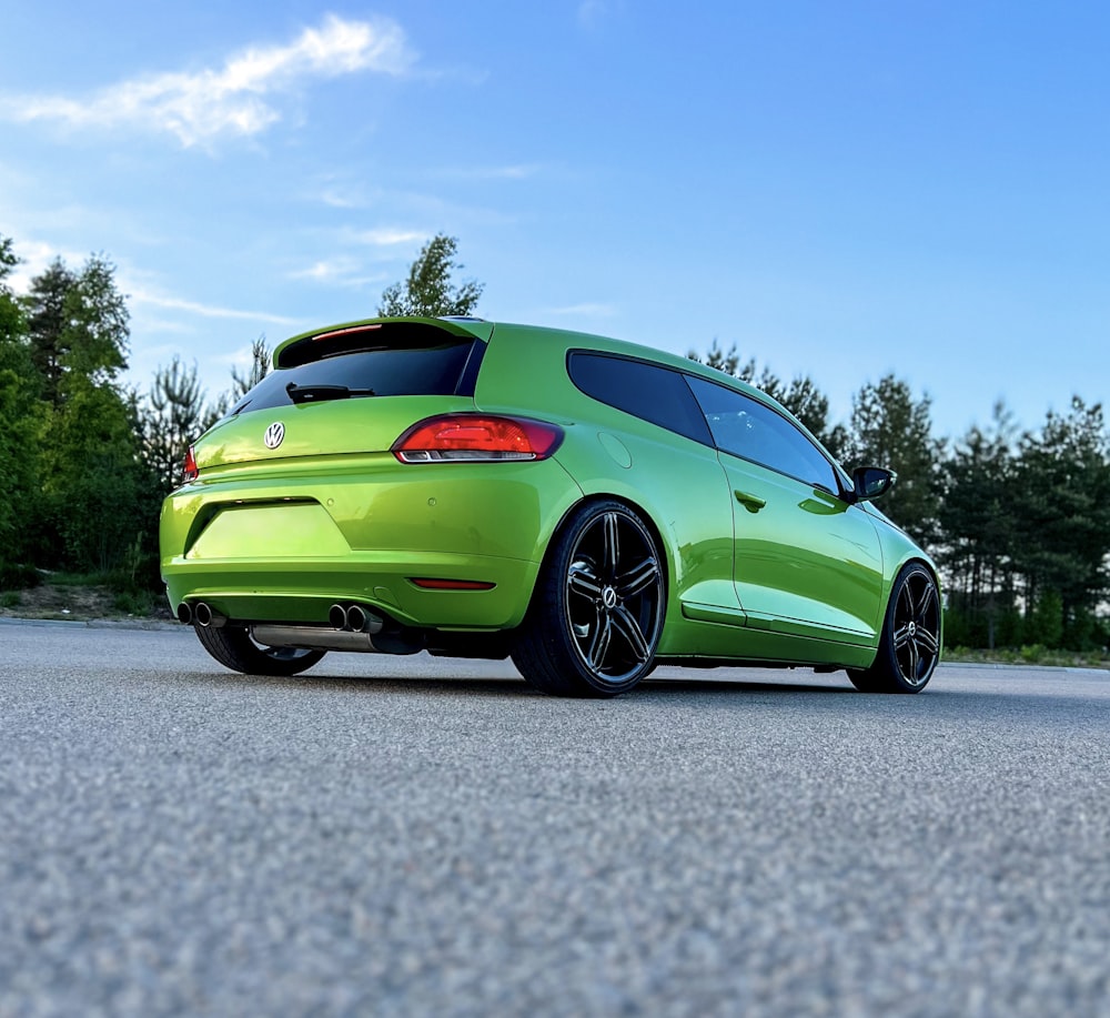 a green car parked on the side of a road