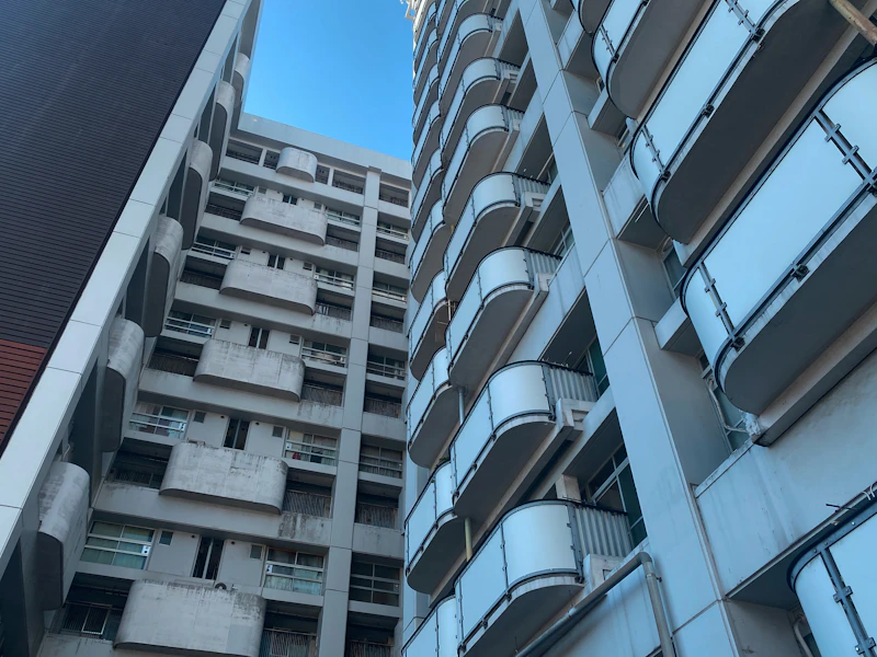 青空に伸びる賃貸マンションの外観