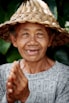 an old woman wearing a straw hat and smiling