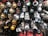 A collection of intricately designed Christmas ornaments featuring popular characters and themes. The ornaments include representations of wizards, stormtroopers, robots, astronauts, and mythical creatures. They are primarily spherical with various decorations and come in a range of colors including gold, black, white, and silver. The display suggests a blend of fantasy and science fiction elements.