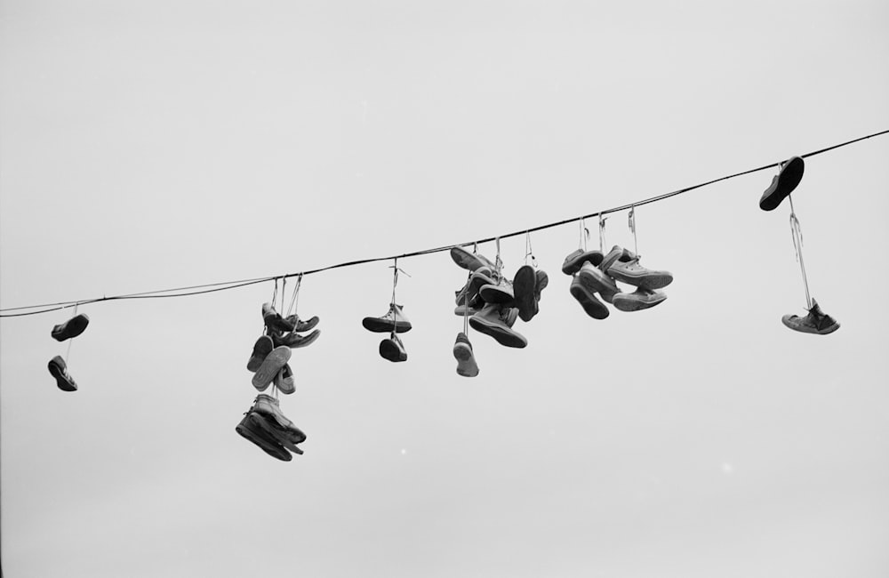 several pairs of shoes hanging from a line