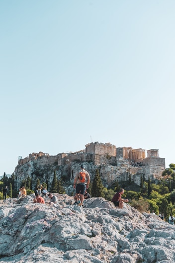 a group of people standing on top of a rocky hill