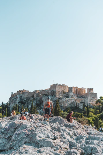 a group of people standing on top of a rocky hill