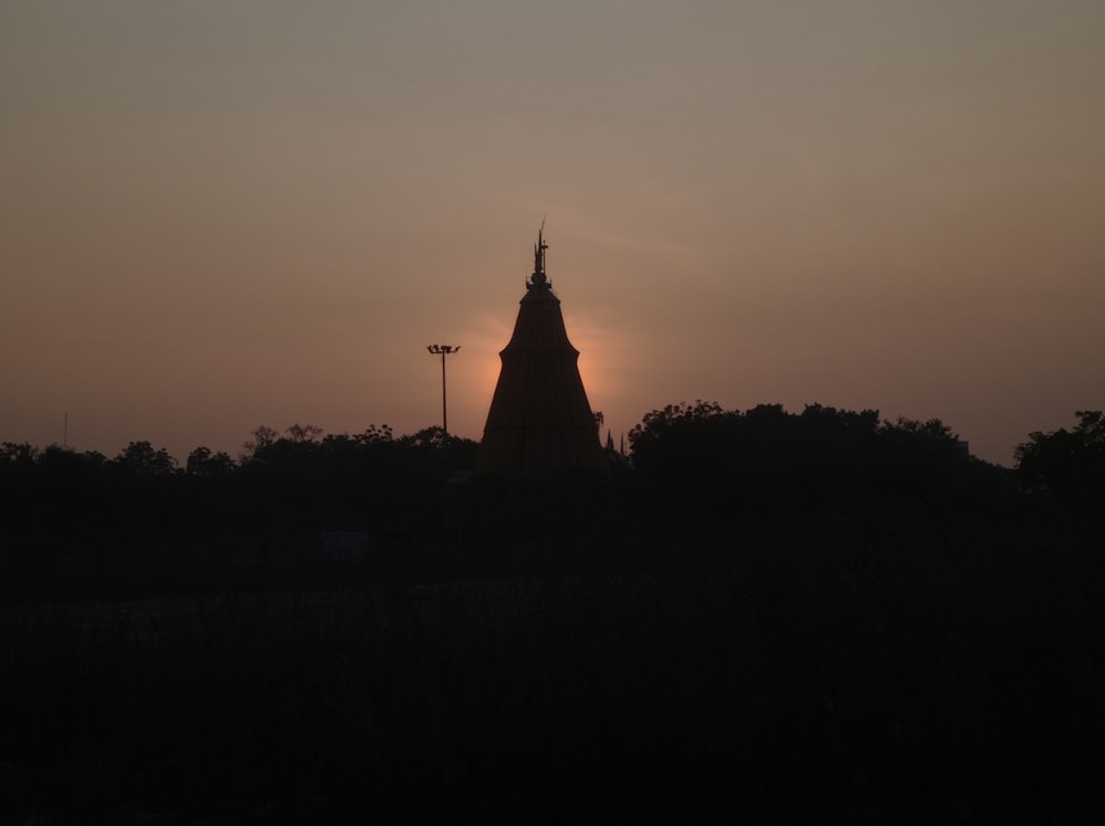 the sun is setting behind a church tower