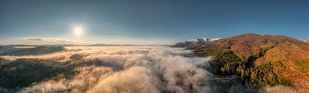 an aerial view of a mountain range covered in clouds