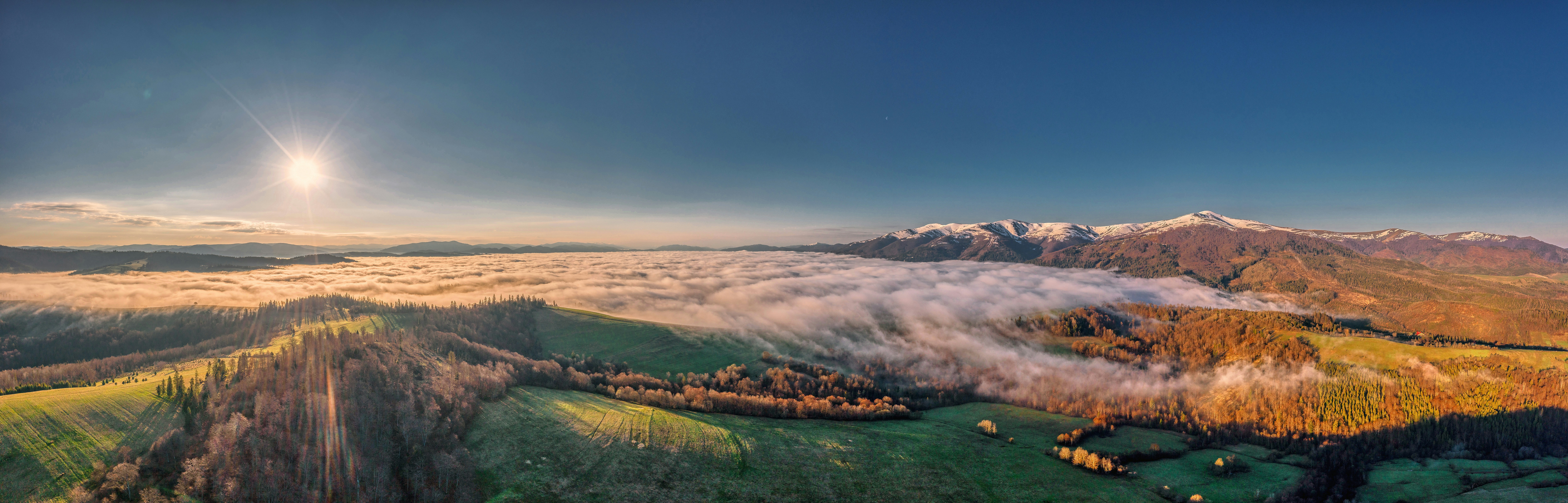 an aerial view of a mountain range with low lying clouds