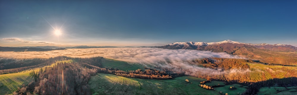 an aerial view of a mountain range with low lying clouds