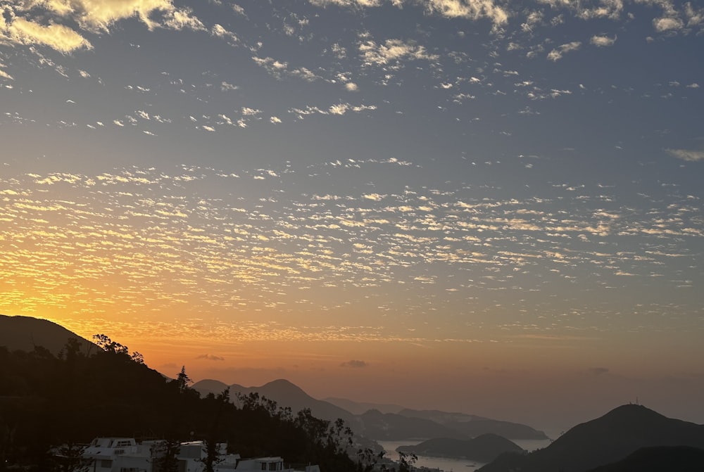 the sun is setting over a mountain range