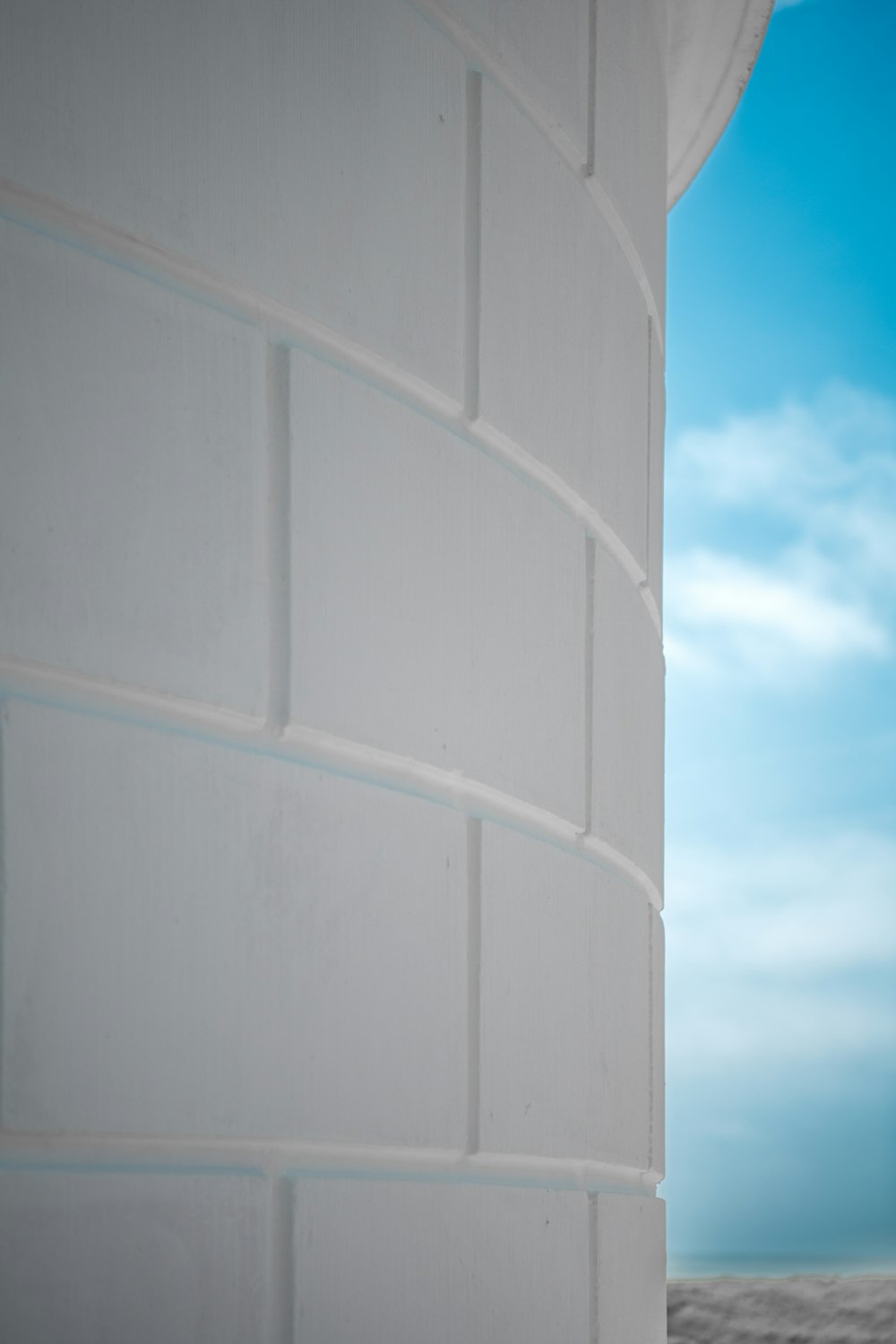 uma parede de tijolos brancos com um céu azul no fundo