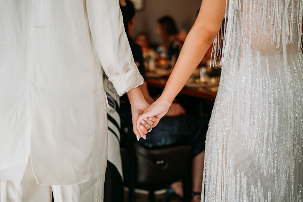 a bride and groom holding hands at a wedding