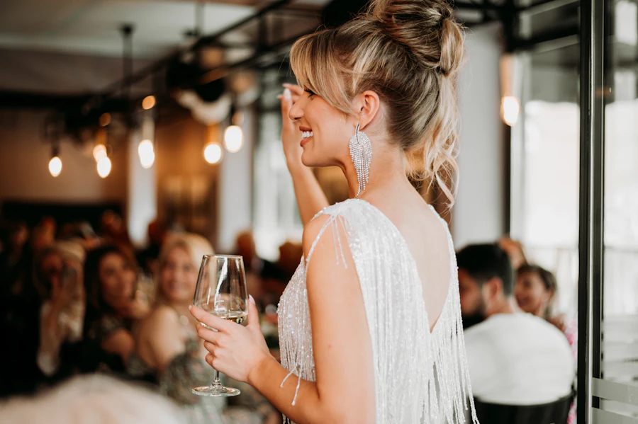 Woman in a white dress holding a glass at a celebration