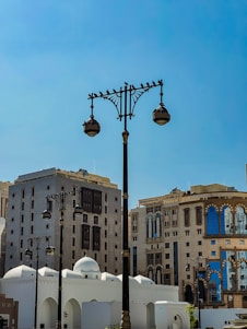 A vibrant street scene in Riyadh blending modern skyscrapers with traditional Arabian architecture under a clear blue sky.