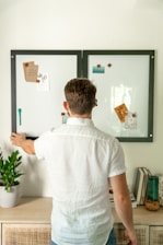 a man standing in front of a whiteboard with magnets on it