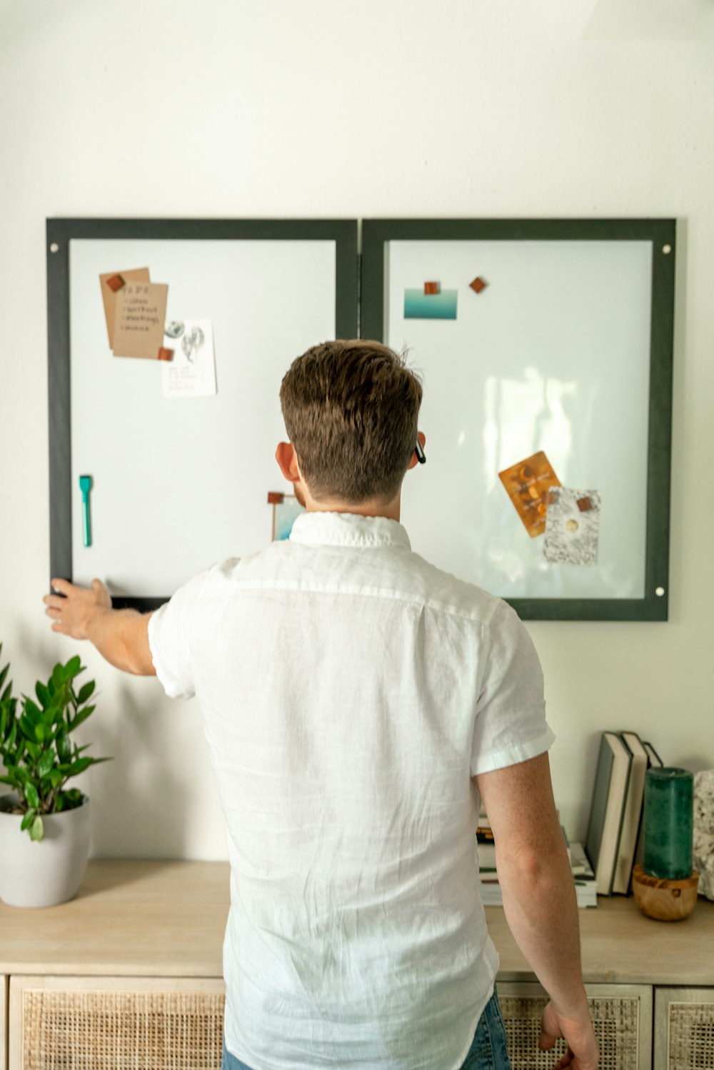 a man standing in front of a whiteboard with magnets on it
