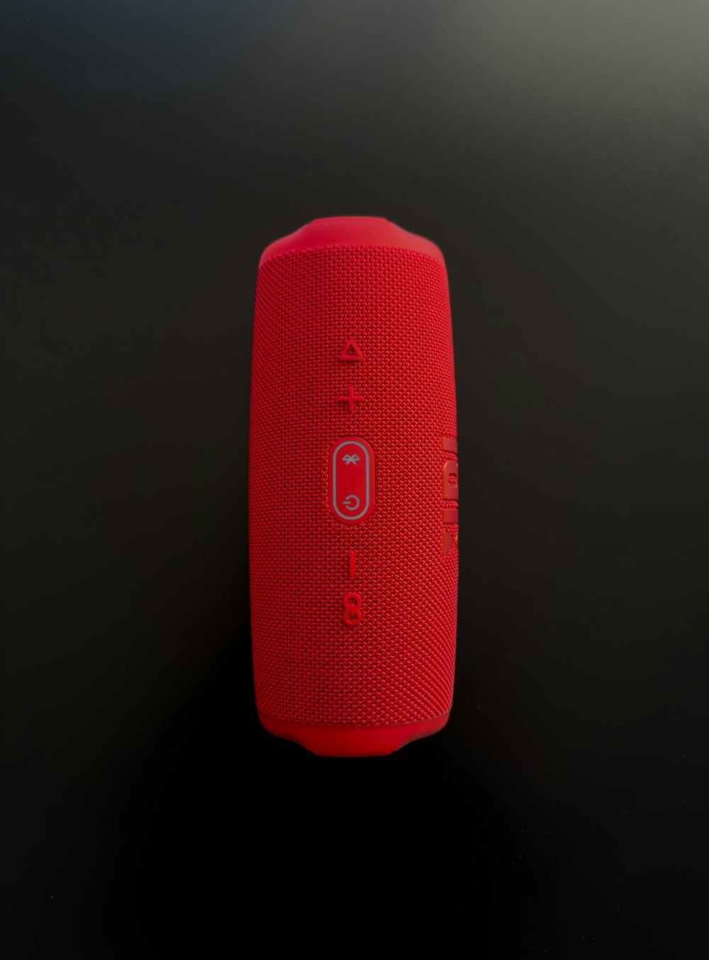 a red speaker sitting on top of a table