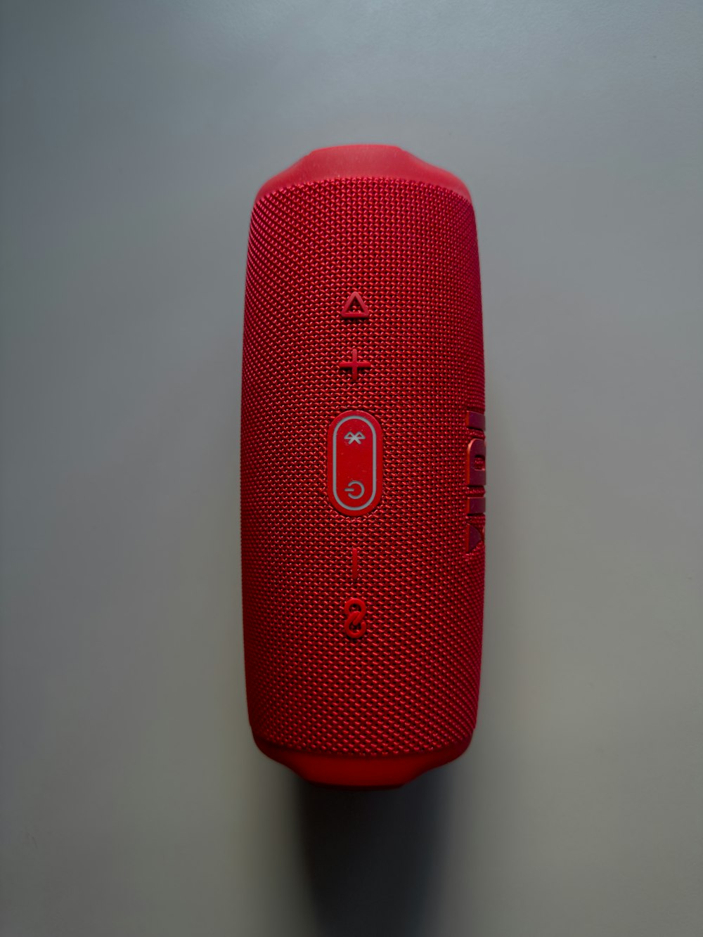 a red portable speaker sitting on top of a table