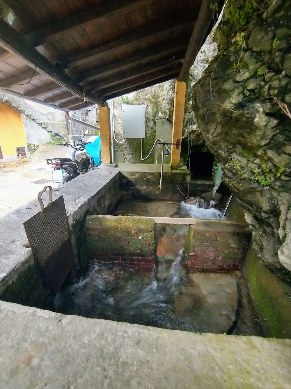 a small stream of water running through a stone wall