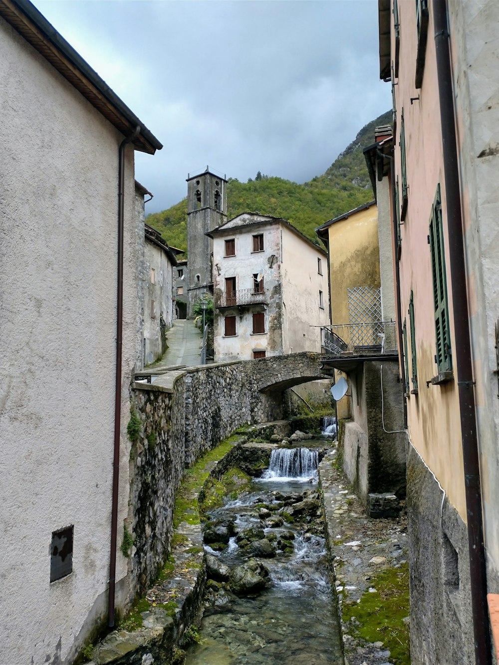 a river running through a small town next to tall buildings