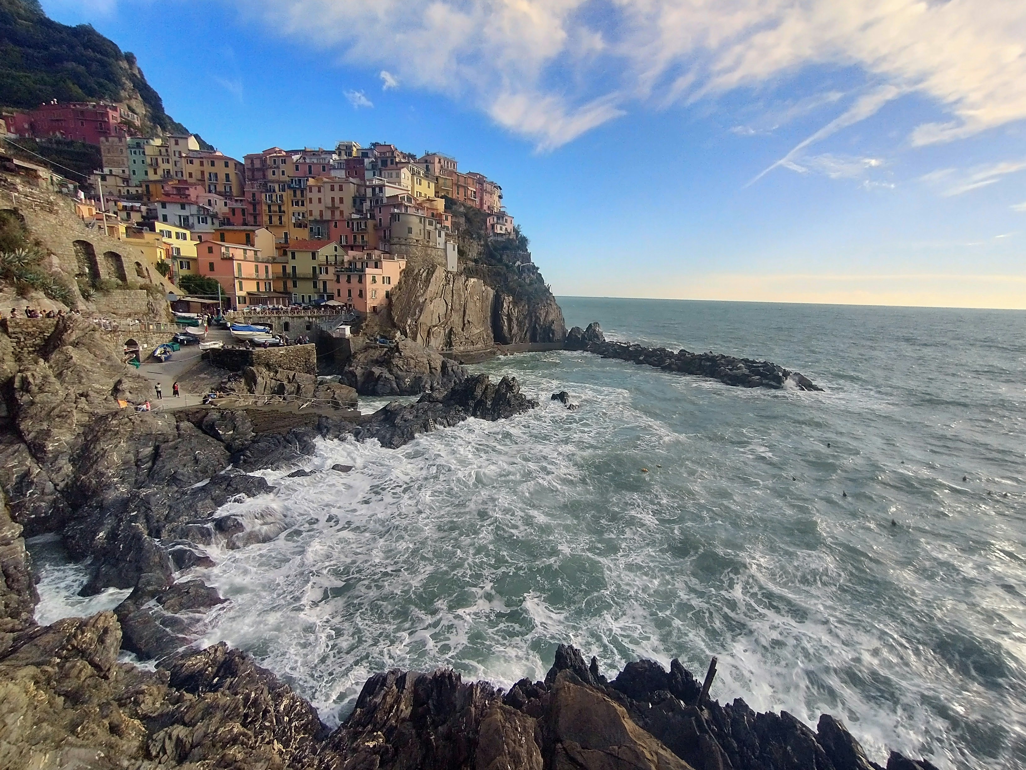 A rocky cliff overlooks the ocean and houses