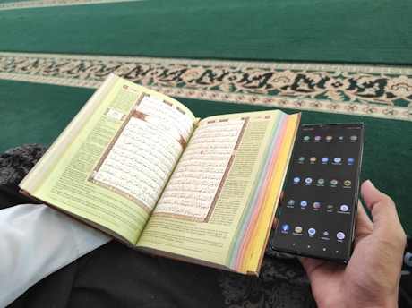 A student reading Quran on a tablet with a teacher guiding via video call.