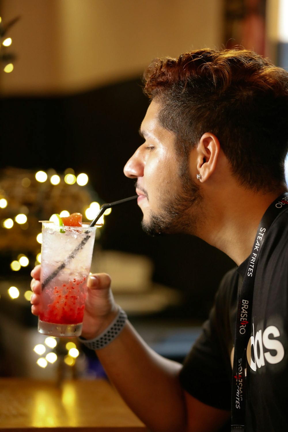 a man sitting at a table drinking a drink