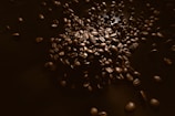 Close-up of tea leaves and coffee beans artfully scattered on a textured surface.