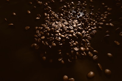 Close-up of tea leaves and coffee beans artfully scattered on a textured surface.