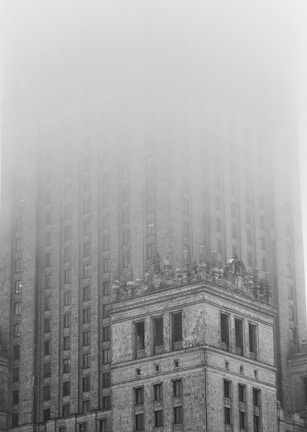 a very tall building in the middle of a foggy day