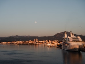 A serene sunrise over a quiet international harbor with ships docked.