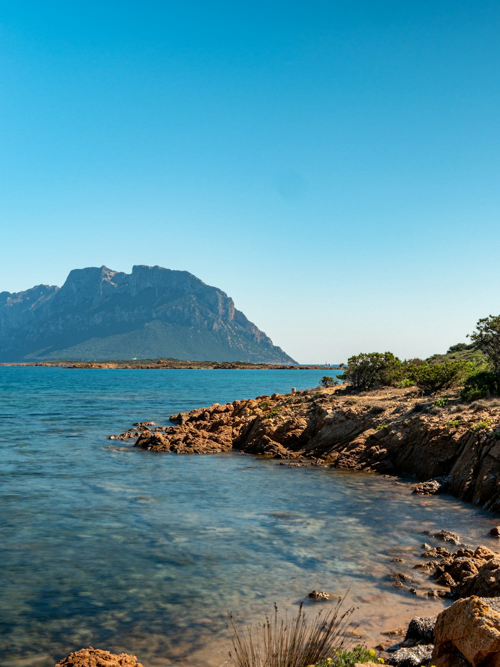 a large body of water with a mountain in the background