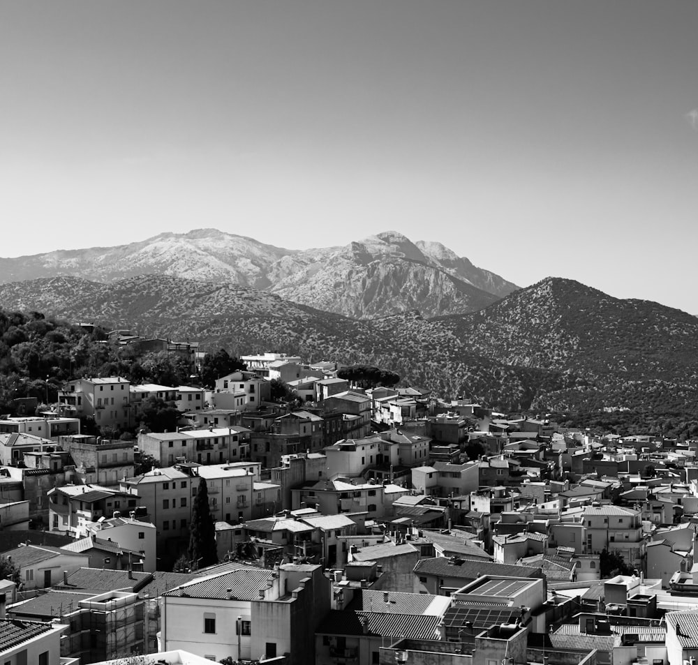 a black and white photo of a city with mountains in the background