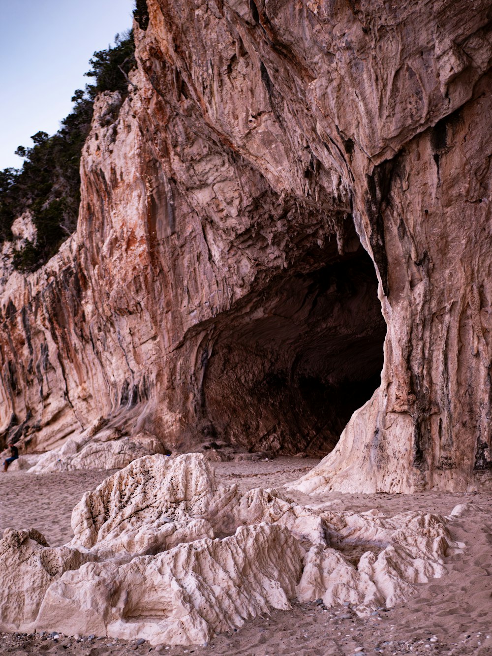a man standing in a cave on the beach