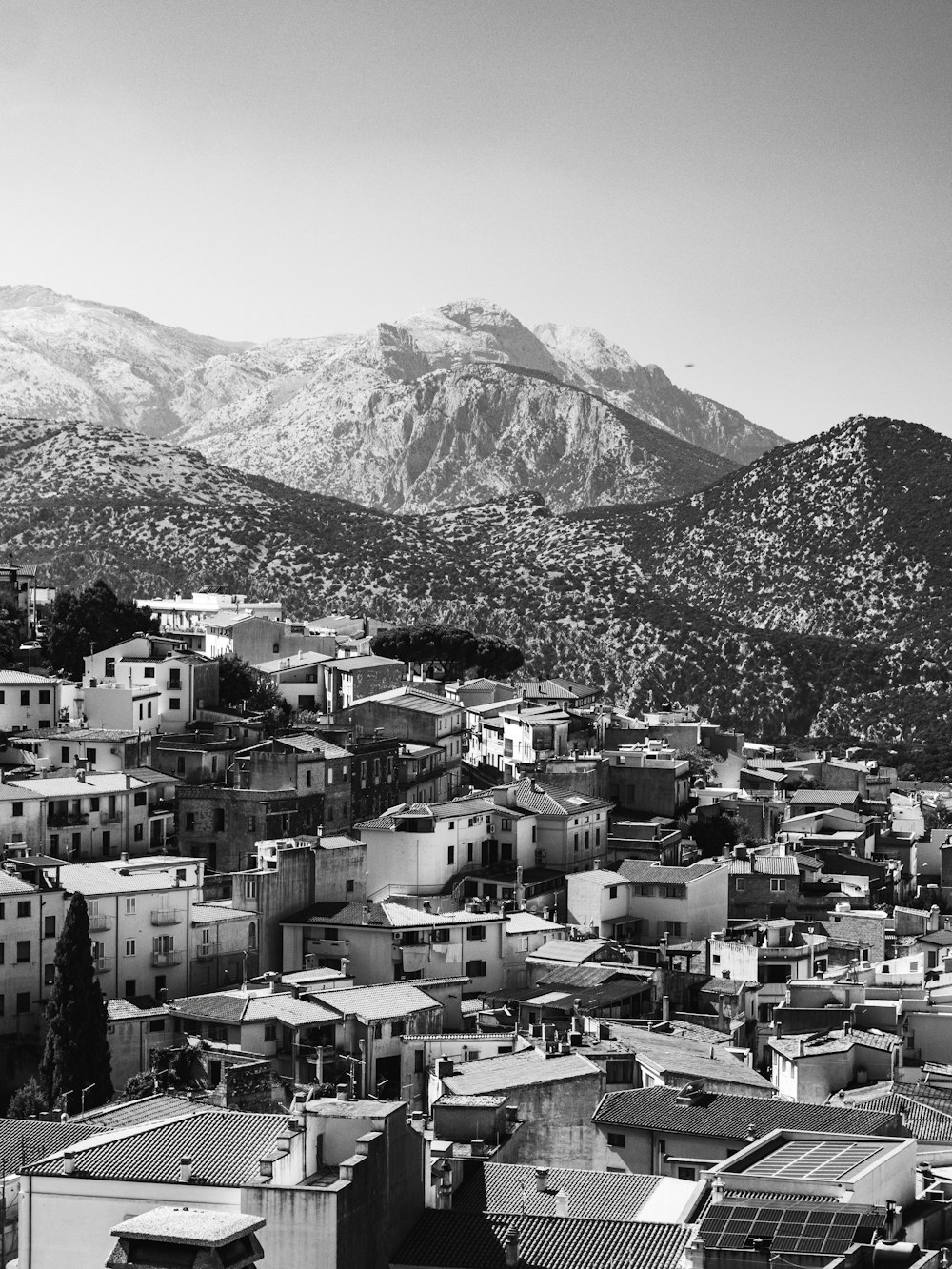 a black and white photo of a city with mountains in the background