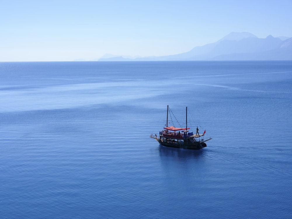 a boat floating in the middle of a large body of water