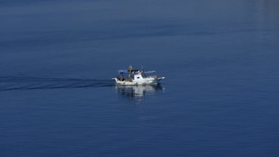 A powerful fishing boat cutting through the calm morning sea near Shengjin shore.