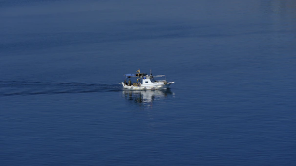 A recreational boat cruising on calm waters with a marine communication radio visible near the helm.