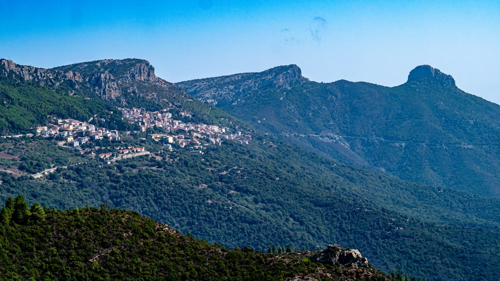 a scenic view of a town nestled in the mountains