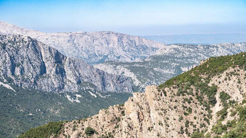 a view of a mountain range from the top of a hill