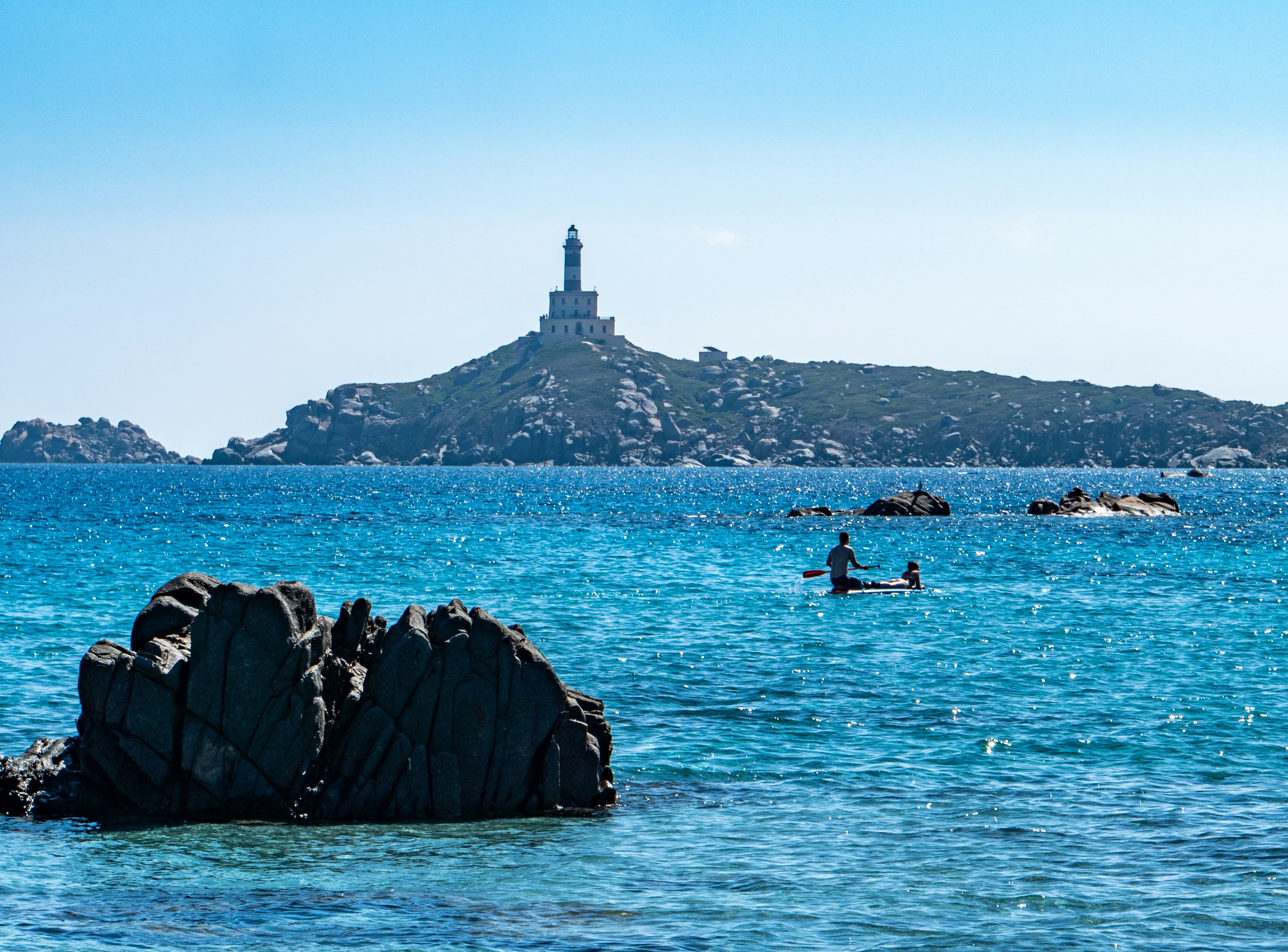 eine Person in einem Kajak im Wasser in der Nähe einer Insel