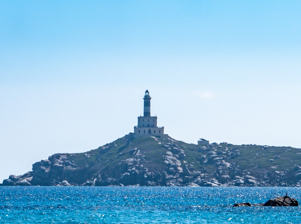 a light house on a small island in the middle of the ocean