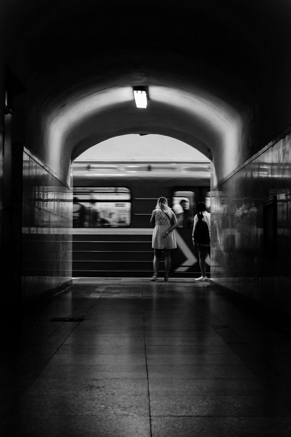 um casal de pessoas que estão em pé em um túnel