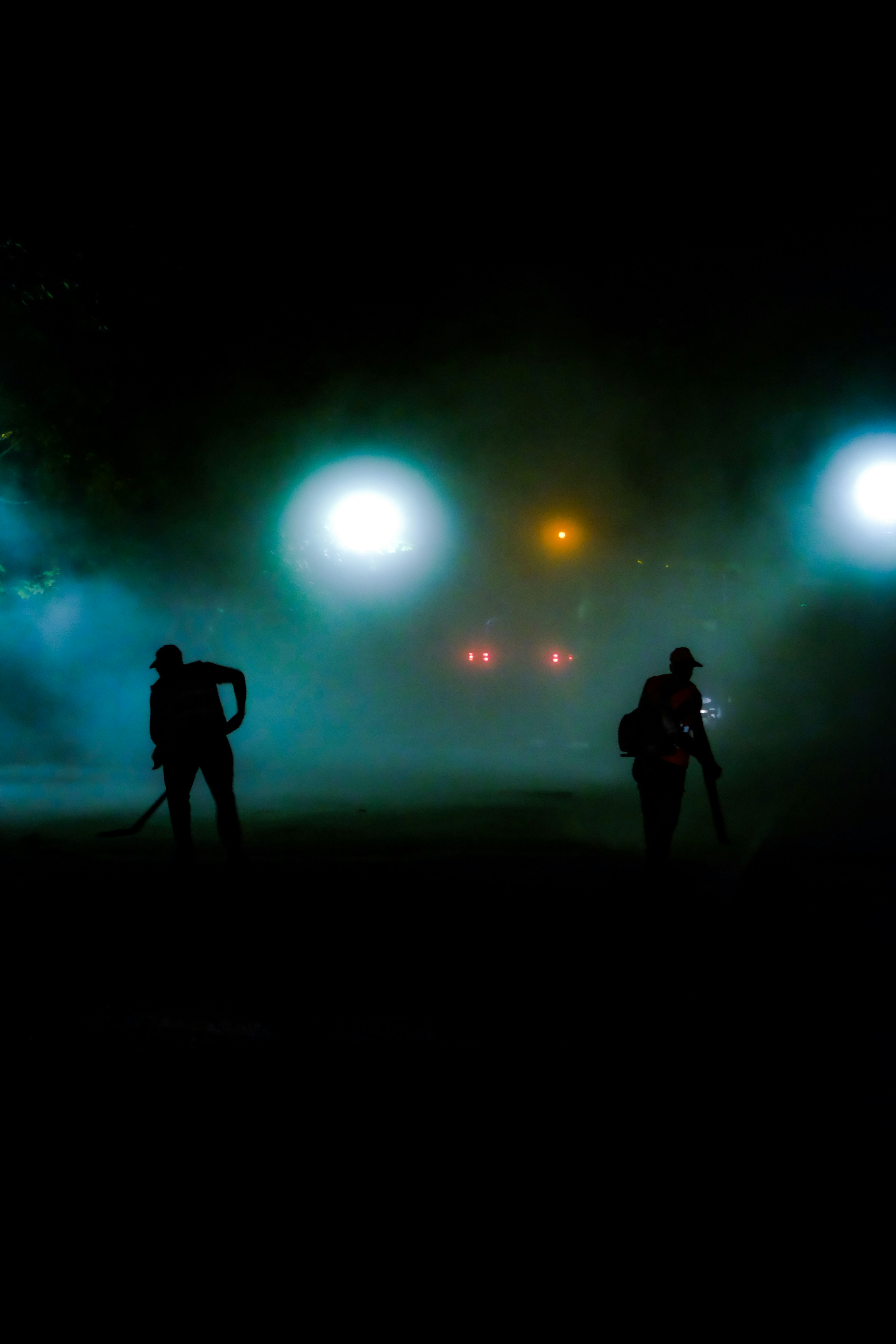 a couple of people that are standing in the dark