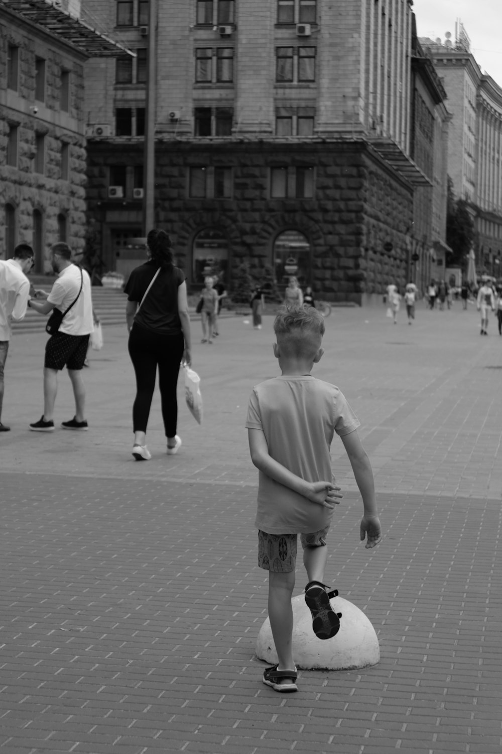 a young boy standing on top of a soccer ball