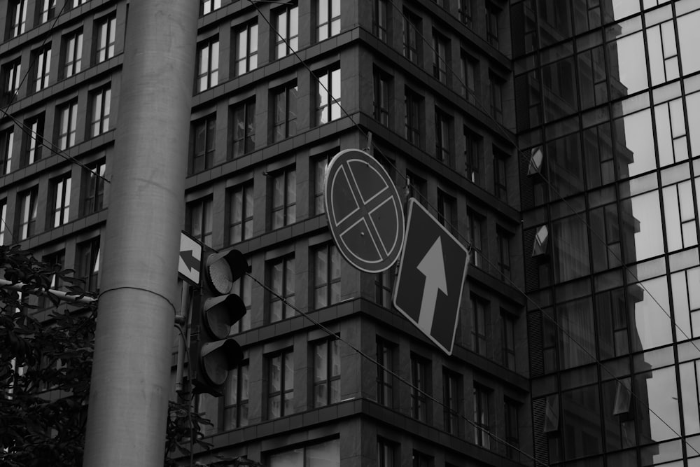 a black and white photo of a street sign in front of a tall building